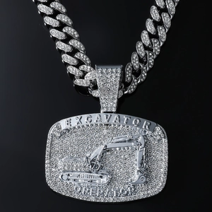 Macro view of iced out silver excavator pendant with rhinestones on Cuban link chain