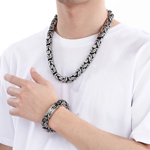 Close-up of men's hip-hop style silver and black woven stainless steel necklace and bracelet set