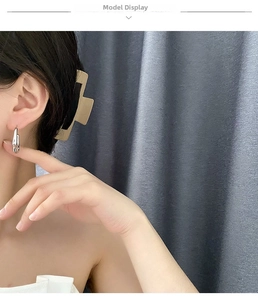 Orecchini a cerchio fluidi a forma di C in argento lucido indossati da una modella