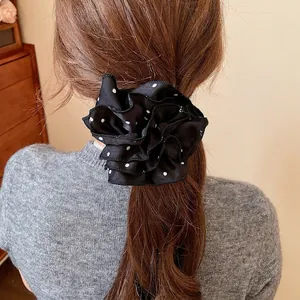 Chouchou à pois noir et blanc porté en queue de cheval pour une coiffure douce et élégante