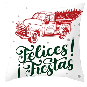 Detail view of a white Christmas cushion cover with red truck and green Felices Fiestas text