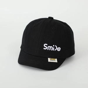 Detail der schwarzen Kinder-Baseballkappe mit weißem Smile-Stick und seitlichem Etikett