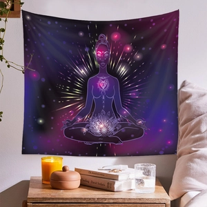 Chakra yoga tapestry with cosmic silhouette hanging over a cozy bedroom nightstand
