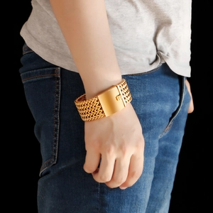 Macro detail of men's wide gold braided wheat chain bracelet with polished buckle