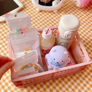 Pink foldable hollow mesh storage crate for desk organization with items inside