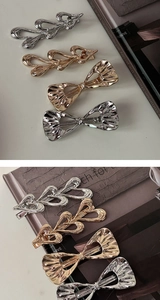 Detailed view of elegant gold and silver metal bow hair clips and heart hairpins