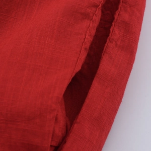 Détail du tissu en coton et lin rouge foncé avec texture et coutures doubles de qualité
