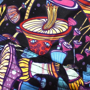 Macro shot of colorful mushroom print on black twill fabric with detailed stitching