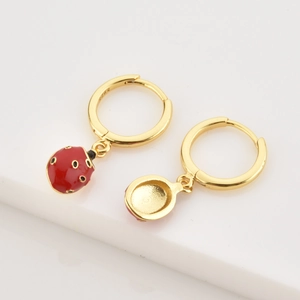 Detailed close-up of S925 sterling silver ladybug earrings with red enamel on white steps