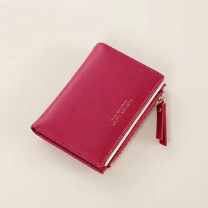 Close-up of a rose red short wallet with gold metal zipper and Forever Lucky lettering