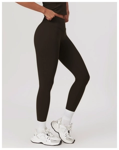 Side view of dark brown high-waisted yoga leggings and tight fitness top on a model