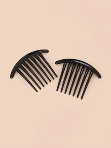 Top-down view of a pair of black curved plastic hair combs for styling on beige background