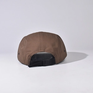 Rear view of brown 5-panel camper cap showing adjustable nylon strap and buckle