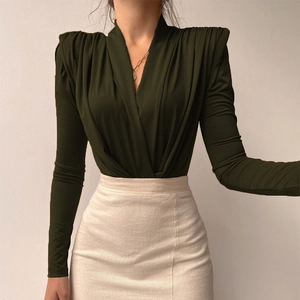 Detail eines dunkelgrünen Wickel-Bodysuits mit plissierten Schulterpolstern und V-Ausschnitt
