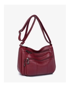 Detail view of burgundy soft leather crossbody bag with three functional front zippers