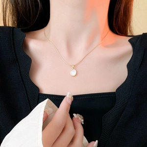 Collier en acier titane doré avec pendentif ovale blanc porté par un mannequin