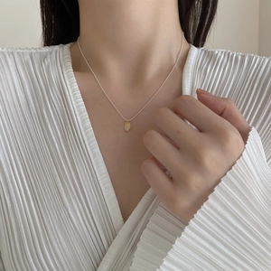 Detail of 925 silver beaded necklace with oval gold portrait relief pendant on model