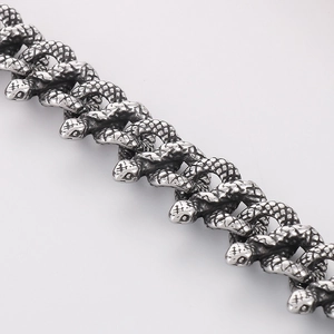 Macro shot of silver snake-shaped chain links with detailed scale texture and craftsmanship