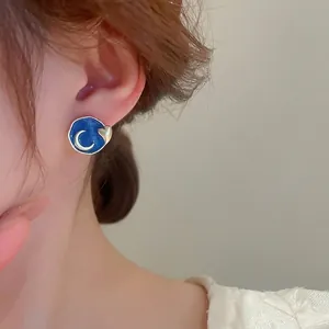 French enamel stud earrings with moon and heart motifs on a deep blue round surface