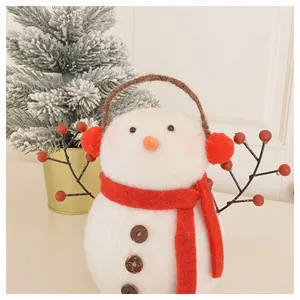 Detailed close-up of wool felt snowman ornament with red scarf in a cozy winter setting