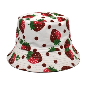 Vue détaillée du motif fraise et pois sur un bob en coton blanc avec coutures précises