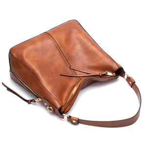 Detail view of smooth zipper closure and textured dark brown leather shoulder bag