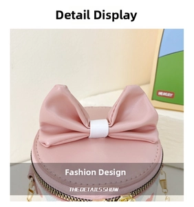 Detailed close-up of a pink bucket bag featuring a large bow and metallic gold zippers