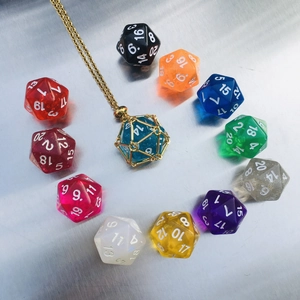 Close-up of D20 dice necklace collection with golden mesh cage and colorful resin pendants