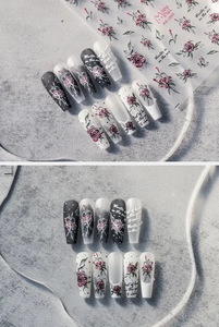 Détail de stickers à ongles fleurs rouges avec motifs roses et texte sur faux ongles
