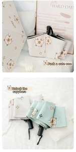 Detailed views of beige and mint green Capybara cartoon folding umbrellas with UV coating