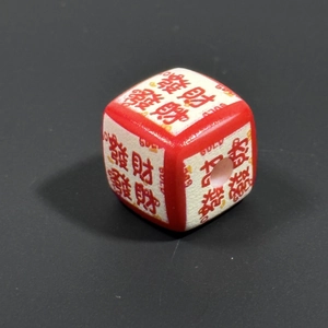 Macro shot of dice-shaped charms featuring Chinese characters for luck and fortune