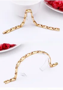 Detailed close-up of golden titanium steel link bracelet with square zirconia inserts