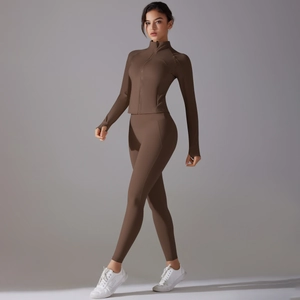 Close-up of slim-fit dark brown yoga set featuring high-collar zip jacket and thumbhole cuffs