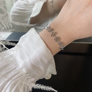 Silver musical note charm bracelet made of stainless steel on a woman's wrist