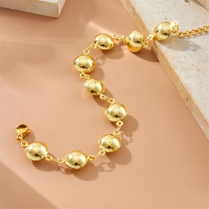 Detail of gold punk-style oval drop geometric link bracelet with lobster clasp