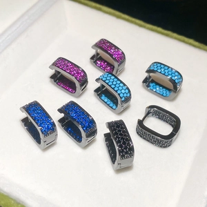 Detail view of square huggie hoop earrings featuring colorful zircon stones in jewelry box