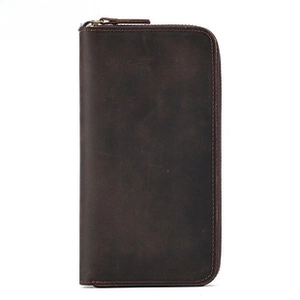 Macro shot of dark brown genuine leather texture and precision stitching on women's long wallet