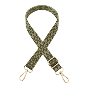 Detail of olive green jacquard bag strap with geometric patterns and gold metal hooks