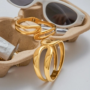 Creative lifestyle display of gold 18K layered hollow cuff bangle with sleek metal lines