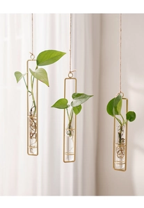 Detailed view of three hanging gold metal frame test tube vases with natural rope