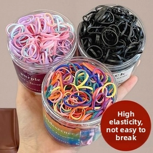 Close-up of three clear jars with colorful high-elasticity hair ties and ballet ribbons