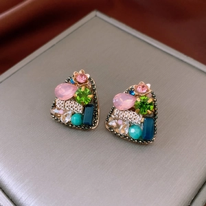 Gros plan de boucles d'oreilles vintage en forme de cœur avec gemmes multicolores