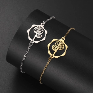 Close-up of gold and silver stainless steel flower bracelets with rose pendant details