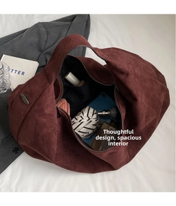 Spacious interior of a dark red suede tote bag filled with daily essentials for storage