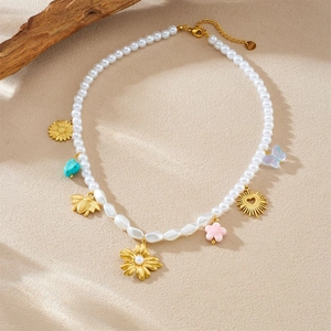 Collier de perles florales avec abeilles et papillons dorés sur un fond naturel