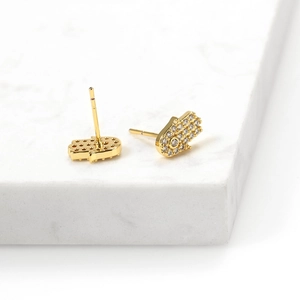 Detailed close-up of Hamsa hand earrings with gold plating and sparkling zircon stones