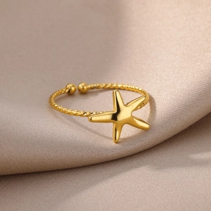 Detailed macro shot of 18k gold starfish ring with a twisted rope adjustable band