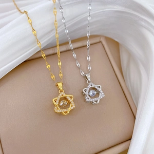 Detailed shot of sparkling gold and silver hexagram necklaces on soft silk background