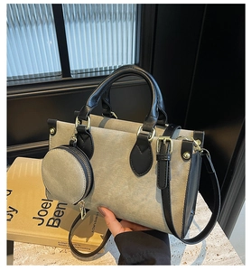 Close-up of color-block tote bag with small round coin purse and gold hardware detail