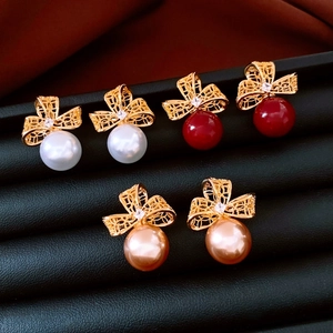 Vue détaillée de boucles d'oreilles fleur en or 18k avec perles et agate sur cuir noir